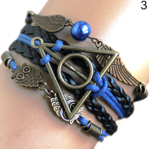 Bracelet bronze bleu Les Reliques de la mort avec hibou d'harry potter et vif d'or sur une main