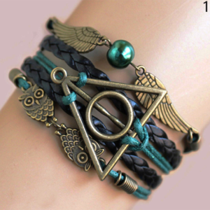 Bracelet bronze émeraude Les Reliques de la mort avec hibou d'harry potter et vif d'or sur une main